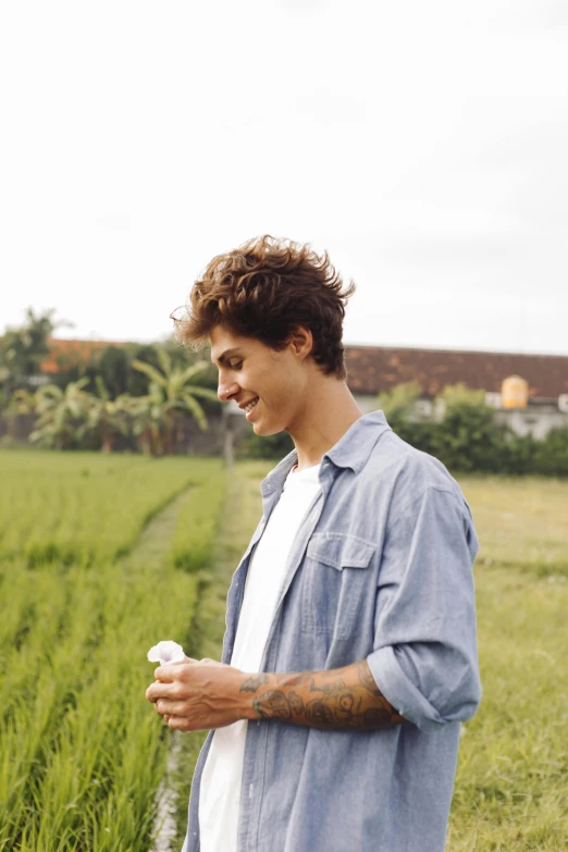 a couple of men standing next to each other in a field, trending on unsplash, he has short curly brown hair, holding a bottle of arak, non binary model, profile image