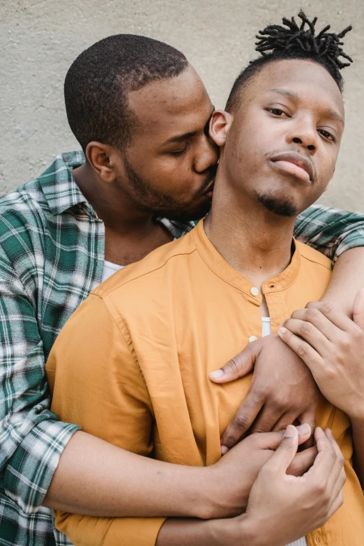 a couple of men standing next to each other, a photo, by Washington Allston, trending on unsplash, hugging each other, queer, african, bowater charlie and brom gerald