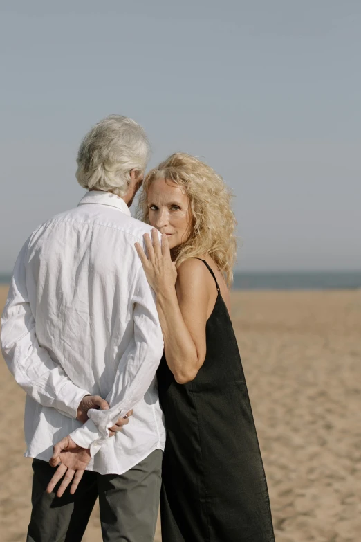 a man standing next to a woman on a beach, curly white hair, 15081959 21121991 01012000 4k, intimate holding close, promo image