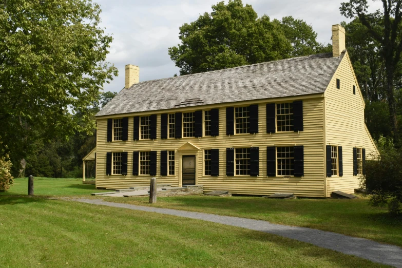 a large yellow house sitting on top of a lush green field, historically accurate, in 1 7 6 7, exterior photo, fan favorite