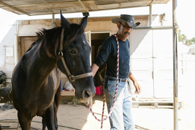 a man that is standing next to a horse, black cowboy, of augean stables, malika favre, rj palmer