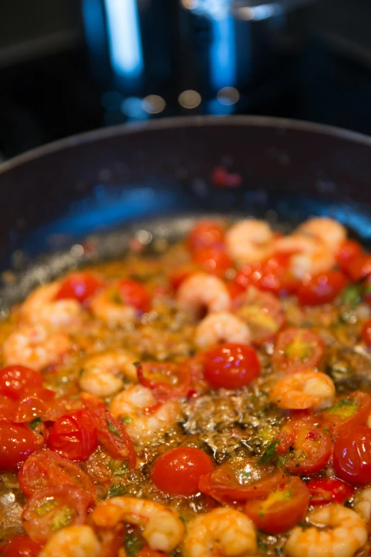 a pan filled with shrimp and tomatoes on top of a stove, by Emanuel Witz, greens), kek, medium angle, uncropped