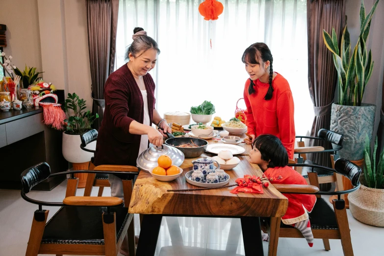 a woman and two children preparing food at a table, by Julia Pishtar, pexels contest winner, mingei, chinese new year in shanghai, thumbnail, joyful people in the house, avatar image