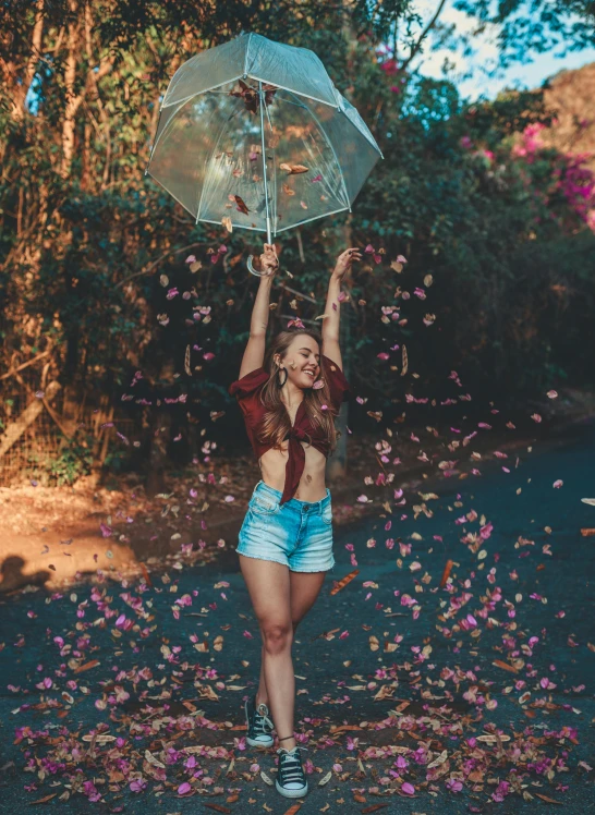 a woman standing in the middle of a road holding an umbrella, petals falling, posing for a picture, avatar image, 5 0 0 px models