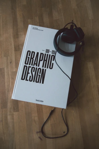 a book sitting on top of a wooden floor next to a pair of headphones, computer graphics, behance, '2d graphic design, graphic tees, have a sense of design, graphics card