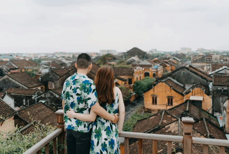 a man and woman standing next to each other on a balcony, pexels contest winner, dreamy chinese town, view(full body + zoomed out), vietnamese woman, tiled roofs