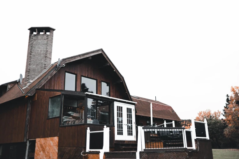 a brown house sitting on top of a lush green field, a portrait, unsplash, maple syrup & hot fudge, overcast skies, restaurant, 90's photo