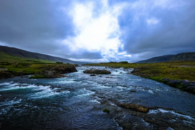 a river running through a lush green valley, an album cover, by Hallsteinn Sigurðsson, pexels contest winner, hurufiyya, under blue clouds, youtube thumbnail, fishing, turbulent water