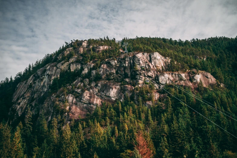 a mountain covered in lots of trees next to a forest, by Chris Rallis, pexels contest winner, gondola, extremely detailed rocky crag, vancouver, nostalgic vibes