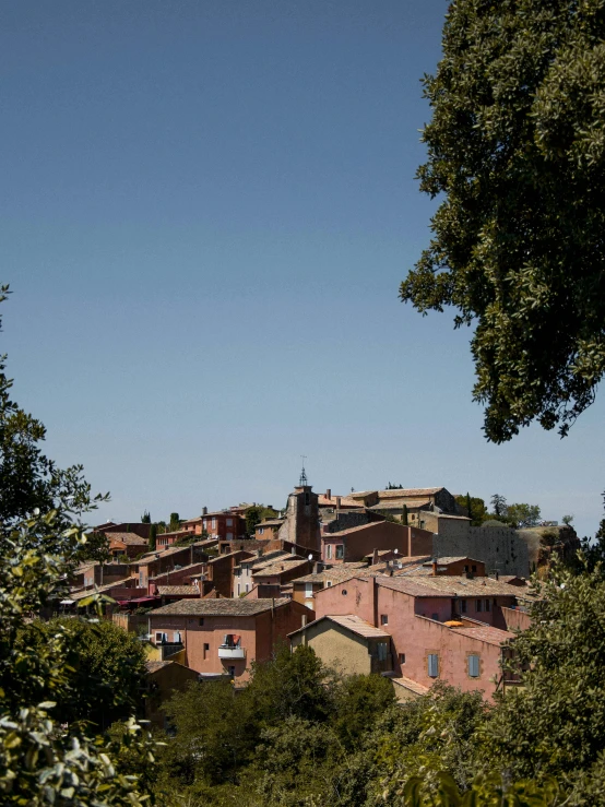 a group of buildings sitting on top of a lush green hillside, inspired by Serafino De Tivoli, les nabis, blue sky, terracotta, view from the streets, giraud