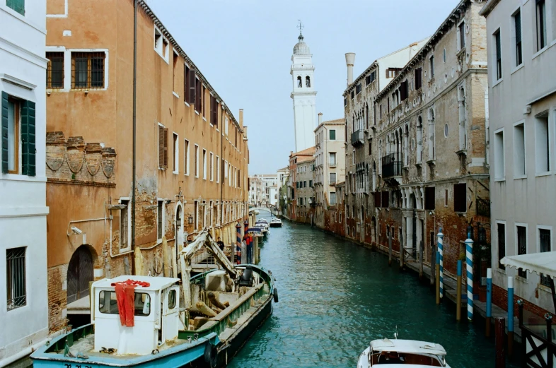 a couple of boats that are in the water, an album cover, inspired by Canaletto, pexels contest winner, alleys, f 1.4 kodak portra, street scene with water tower, viridian and venetian red