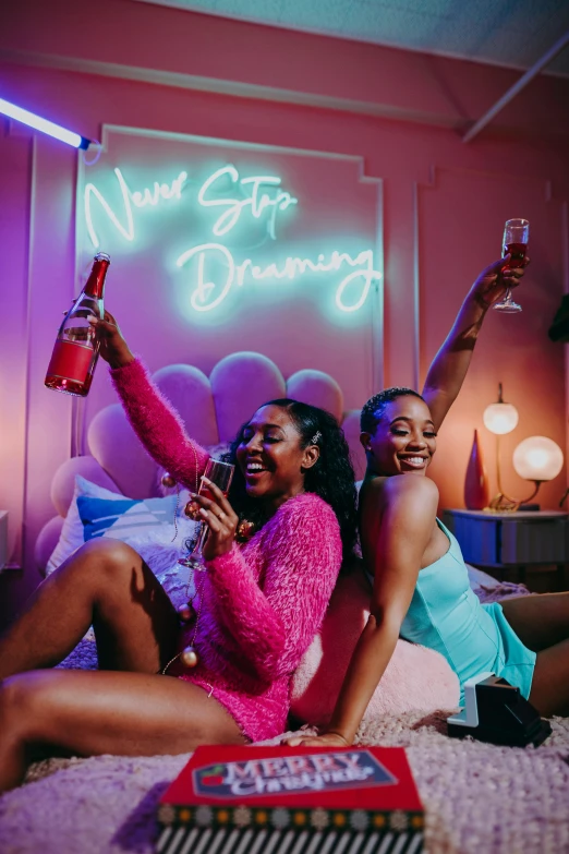 a couple of women sitting on top of a bed, an album cover, trending on pexels, happening, bright neon signs, drinking champagne, the walls are pink, group photo