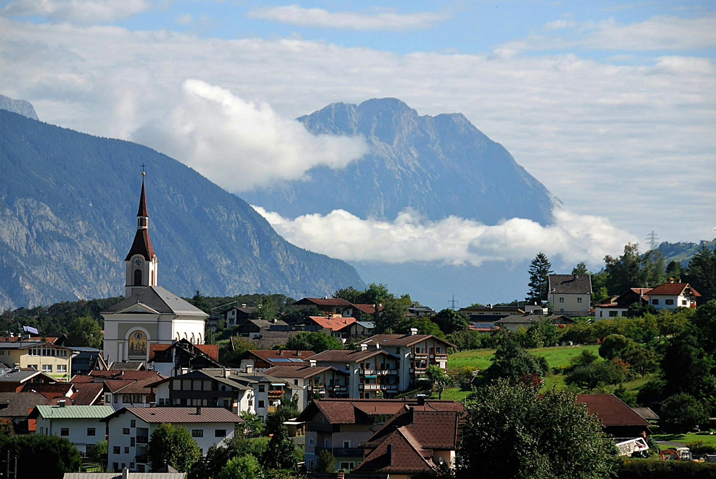 a view of a town with mountains in the background, by Caroline Mytinger, pexels contest winner, herzog de meuron, artgern, avatar image