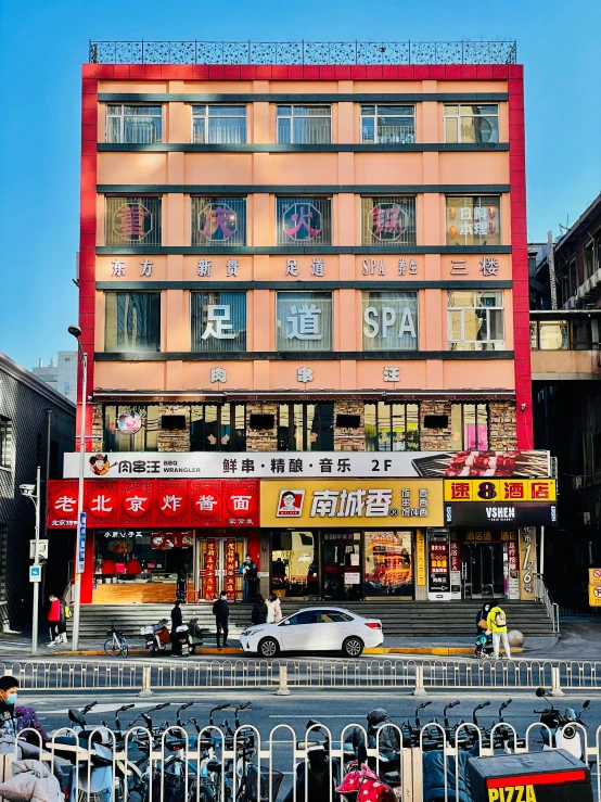 a group of people walking down a street next to a tall building, 中 国 鬼 节, lots of signs and shops, spa, photo for a store