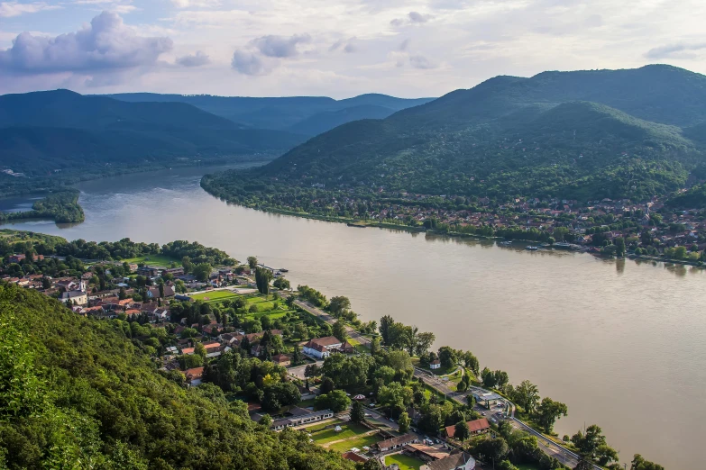 a large body of water next to a lush green hillside, pexels contest winner, danube school, thumbnail, surrounding the city, zig zag, brown