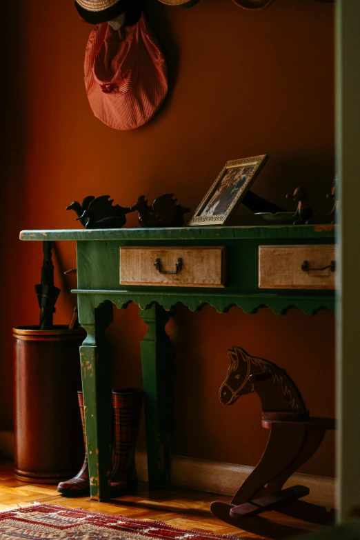 a wooden table sitting on top of a hard wood floor, inspired by Rosa Bonheur, bright green dark orange, hallway, wild west setting, small chest