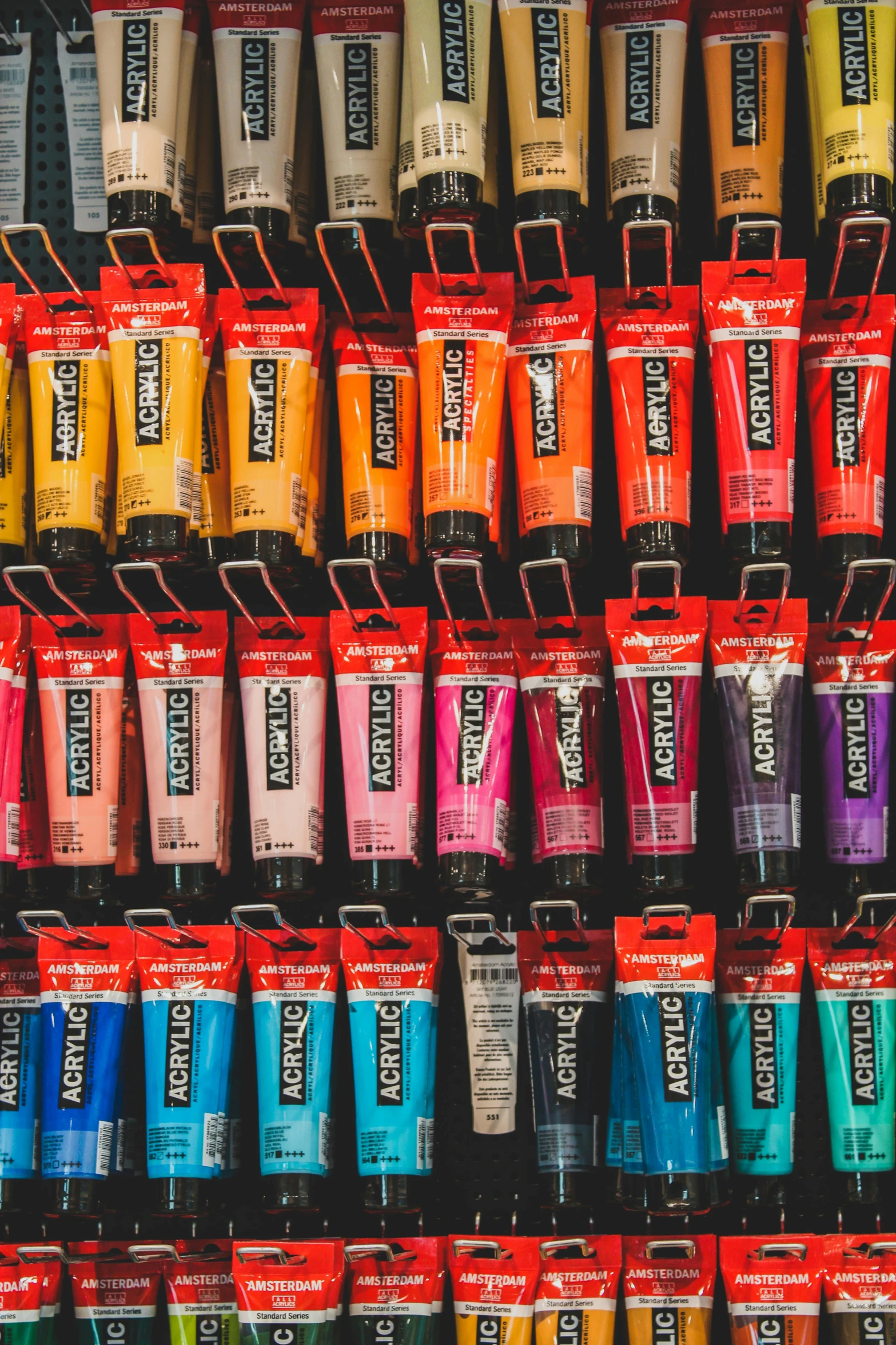 a wall filled with lots of different colors of paint, inspired by Warhol, pexels contest winner, paint tubes, maybelline, trending on artisation, colored market stand