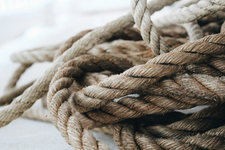 a pile of rope sitting on top of a table, trending on pexels, brown, grey, pov photo, brightly-lit