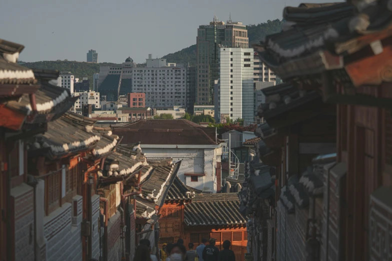 a group of people walking down a street next to tall buildings, by Jang Seung-eop, unsplash contest winner, renaissance, korean traditional palace, city on a hillside, shady alleys, square