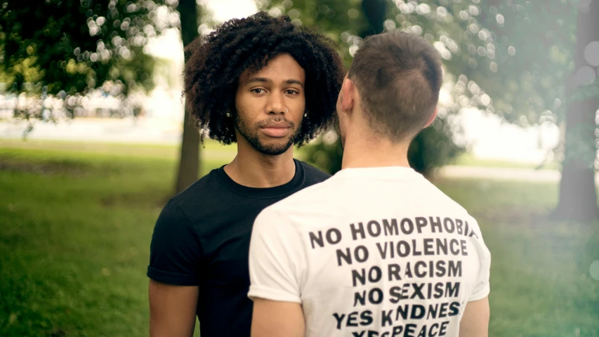 a couple of men standing next to each other, unsplash, antipodeans, with afro, wearing a shirt, gay rights, close - up photograph