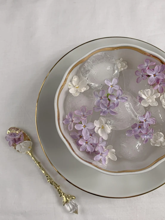 a white plate topped with ice and purple flowers, by Hermione Hammond, rococo, spoon placed, gold and white, thumbnail, lilac