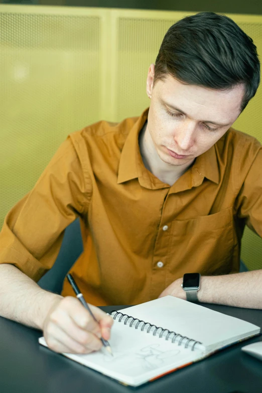 a man sitting at a table writing in a notebook, trending on reddit, academic art, androgynous person, thumbnail, headshot, ignant