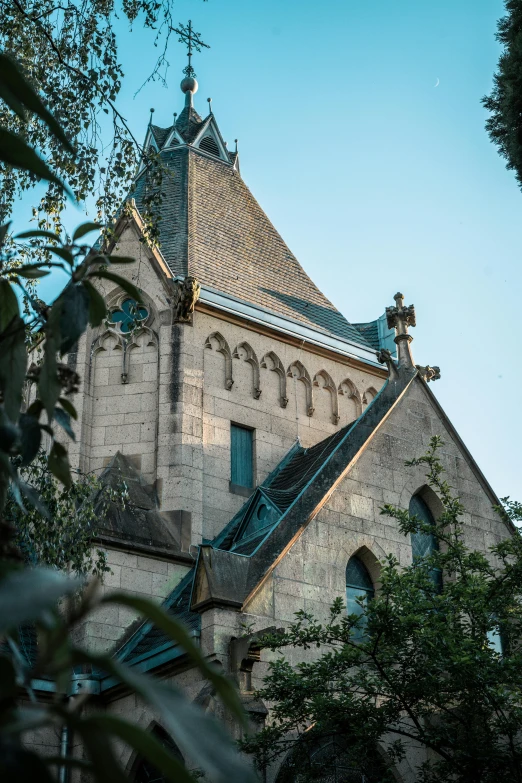 a tall building with a clock on top of it, inspired by Albert Paris Gütersloh, unsplash, romanesque, roof with vegetation, old gothic crypt, ribbon chapel, 1910s architecture