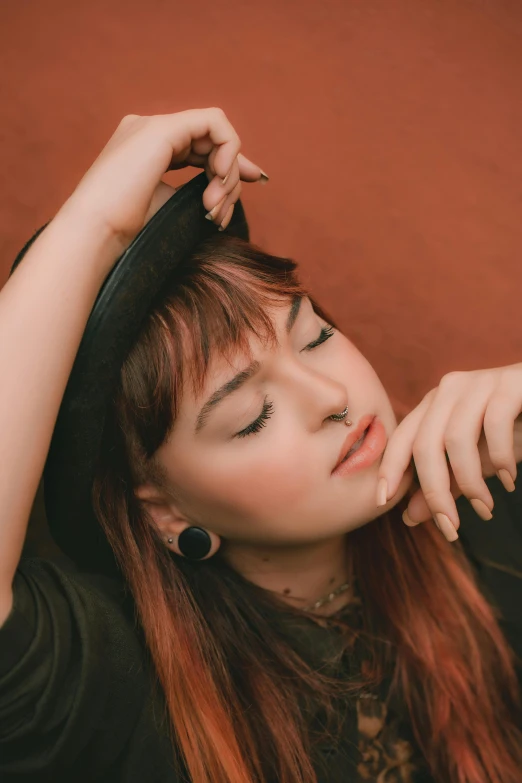 a woman with long red hair wearing a black top, an album cover, inspired by Glòria Muñoz, trending on pexels, resting head on hands, asian woman, woman with hat, brown bangs