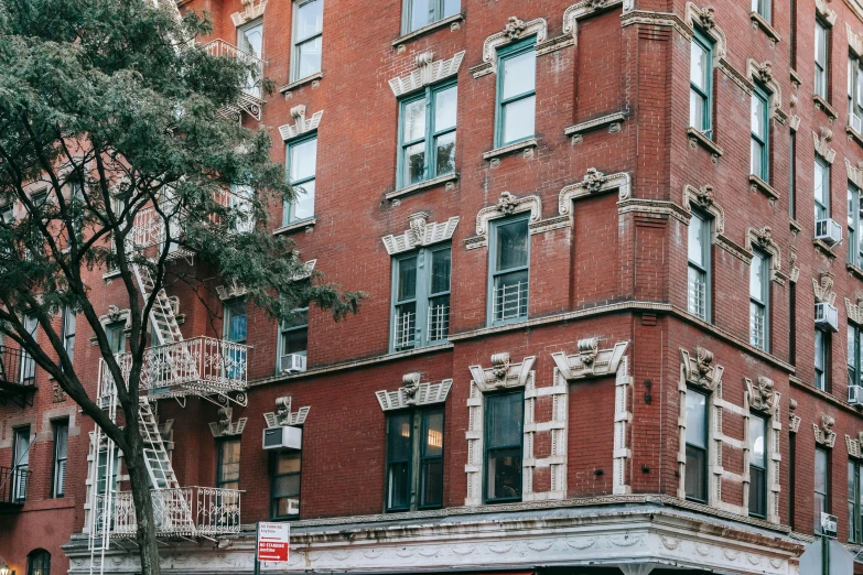 a tall red brick building sitting on the side of a street, by Nina Hamnett, pexels contest winner, rundown new york apartment, very ornamented, ladders, listing image