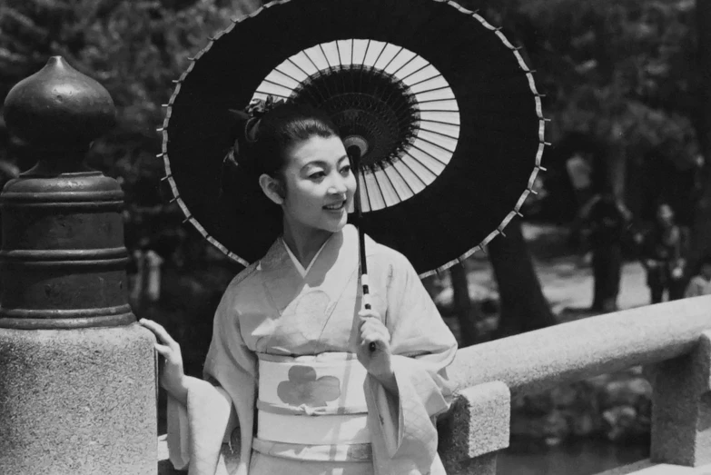 a black and white photo of a woman holding an umbrella, a black and white photo, sōsaku hanga, mikado, tomoyuki yamasaki, the sun is shining, photograph credit: ap