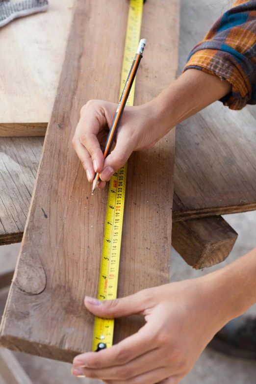 a person measuring a piece of wood with a ruler, teak table, full colour, environmental, worn