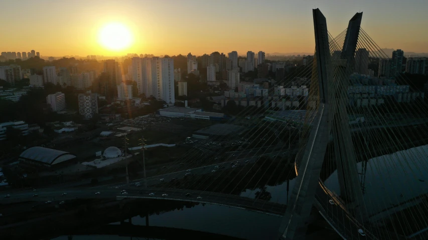 a view of the sun setting over a city, an album cover, by Ceferí Olivé, pexels contest winner, happening, all buildings on bridge, brazilian, view from helicopter, olympics