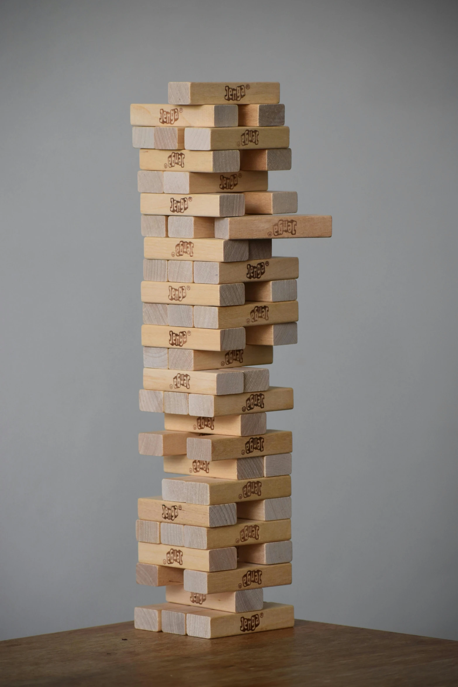 a stack of wooden blocks sitting on top of a table, on a gray background, ap, brock hofer, twister