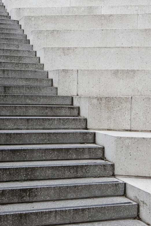 a man riding a skateboard up the side of a flight of stairs, inspired by David Chipperfield, unsplash, brutalism, abstract detail, steps 50, monument, concrete )