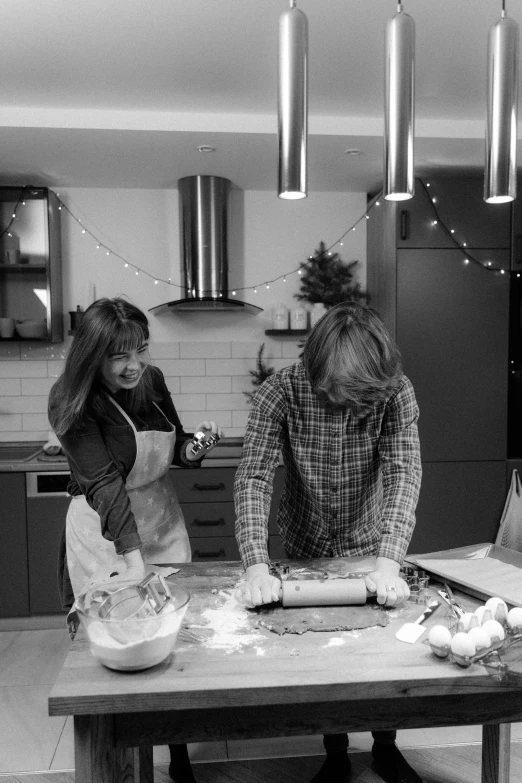 a couple of people in a kitchen preparing food, a black and white photo, by Lucette Barker, christmas night, fiona staples and kinu nishimura, baking cookies, ready to model