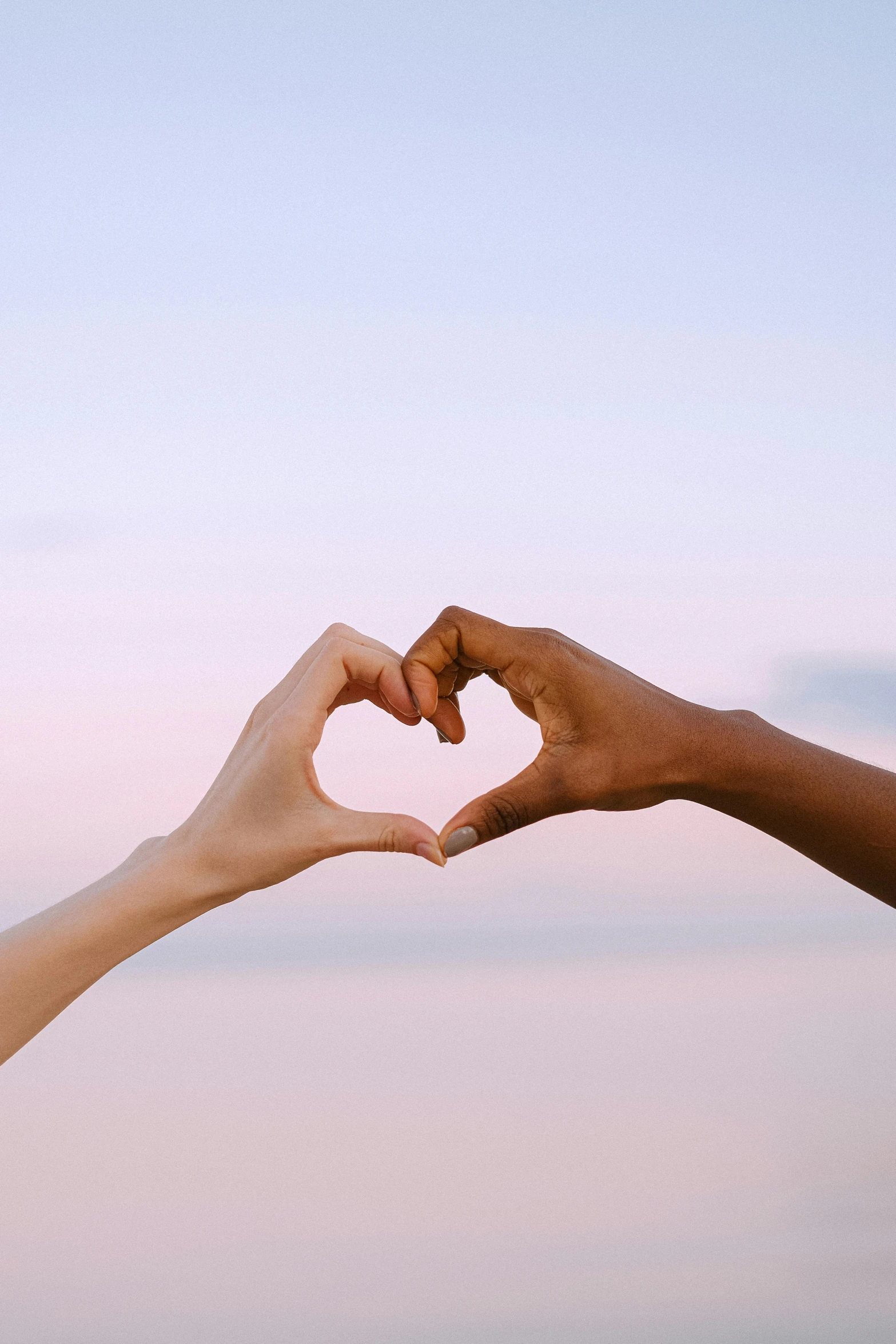 two people making a heart with their hands, by Carey Morris, pexels, varying ethnicities, ✨🕌🌙, profile image, beautiful shades