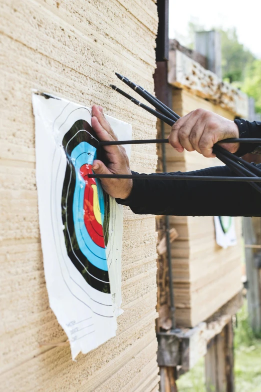 a man is aiming an arrow at a target, trending on pexels, top-down shot, panels, holding a bow, multi - layer