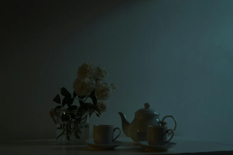 a tea pot sitting on top of a table next to a cup, inspired by Elsa Bleda, romanticism, album cover, low quality photo, night photo