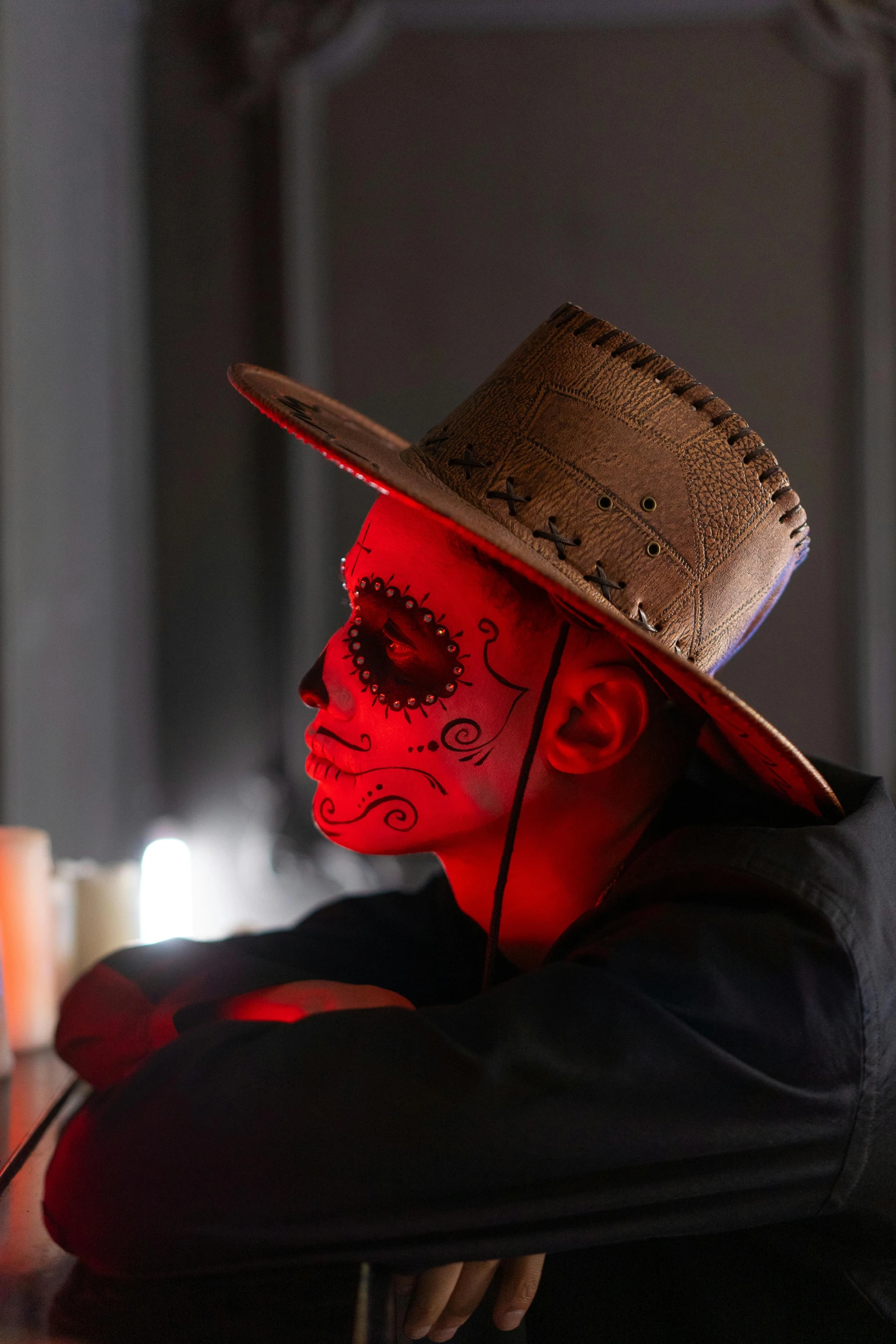 a close up of a person wearing a hat, vanitas, glowing red skull, dia de muertos, glowing ceremonial markings, red cloud light