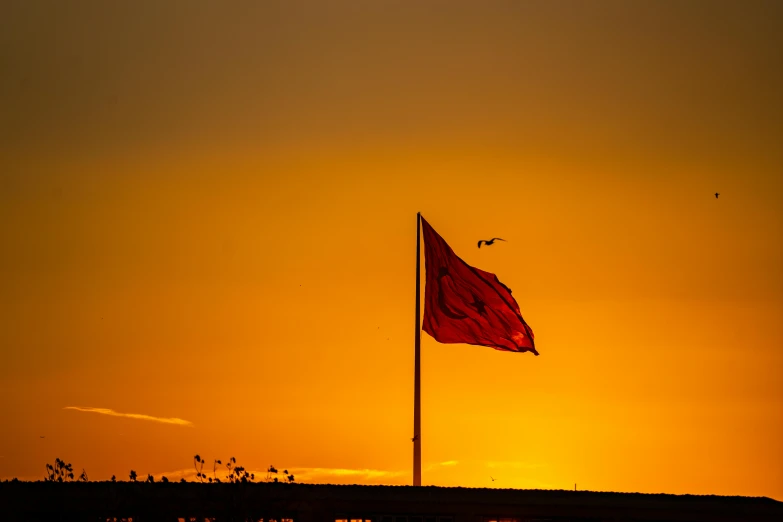 a red flag flying in the wind at sunset, by Dave Melvin, harbor, ((sunset)), moroccan, square