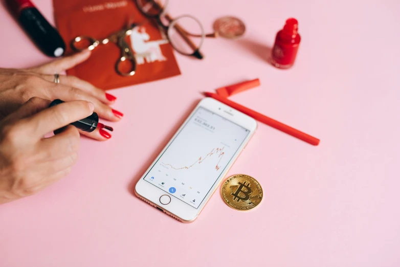 a close up of a person using a cell phone, trending on pexels, analytical art, bitcoin, pink, flatlay, red