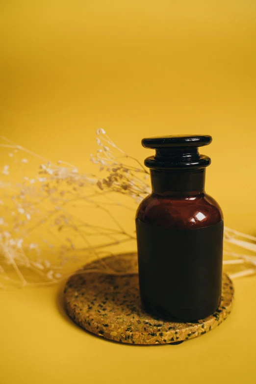 a brown bottle sitting on top of a table, unsplash, black and yellow, apothecary, thumbnail, skincare