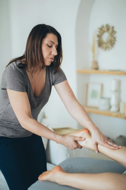 a woman getting a foot massage at a spa, by Dan Content, pexels contest winner, renaissance, standing sideways, prosthetic limbs, square, low quality photo