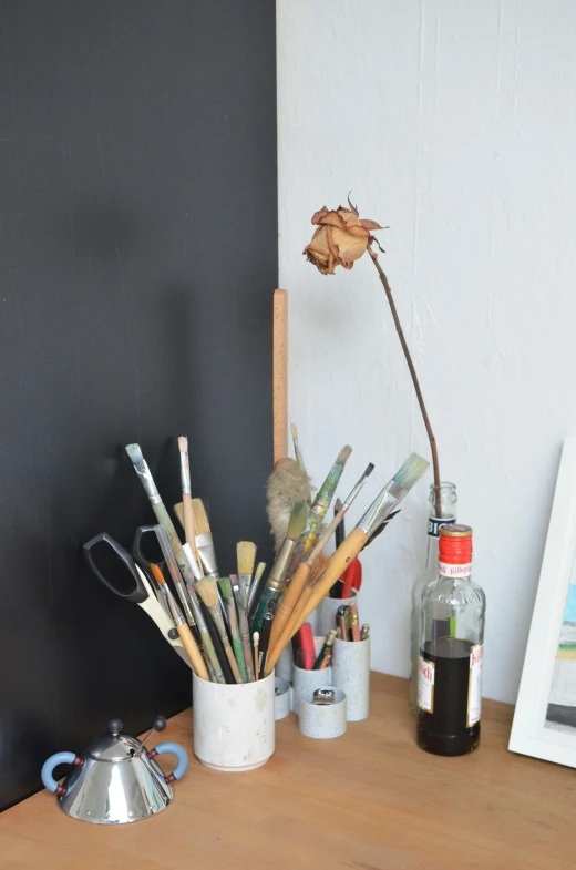 a wooden table topped with a vase filled with art supplies, by artist, studio room, photo of a rose, illustratioin, wetastudiofx