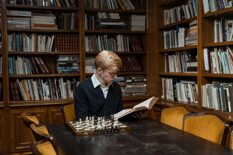 a man sitting at a table reading a book, by Carey Morris, pexels contest winner, academic art, chess tournament, a blond, ellie bamber, ignant