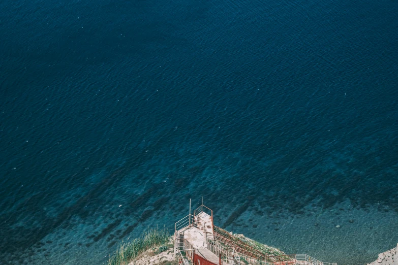 a red and white boat sitting on top of a body of water, by Daniel Lieske, pexels contest winner, stairway to heaven, turquoise rust, satellite view, watch tower