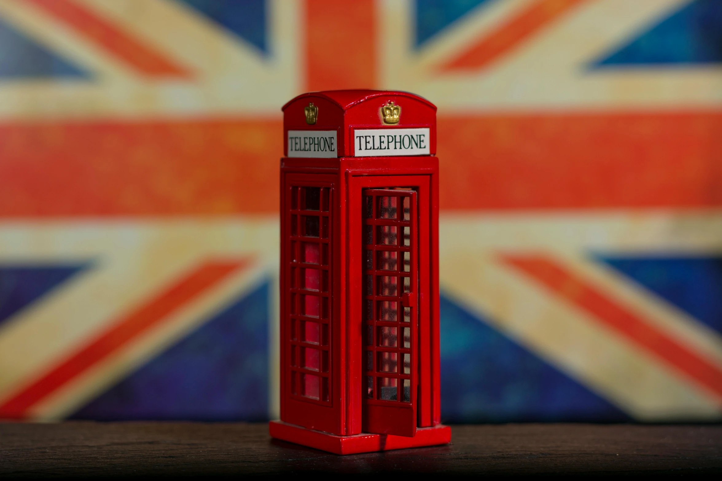 a red telephone box sitting on top of a wooden table, a tilt shift photo, by Romain brook, shutterstock, pop art, united kingdom flags, square, mini model, 15081959 21121991 01012000 4k