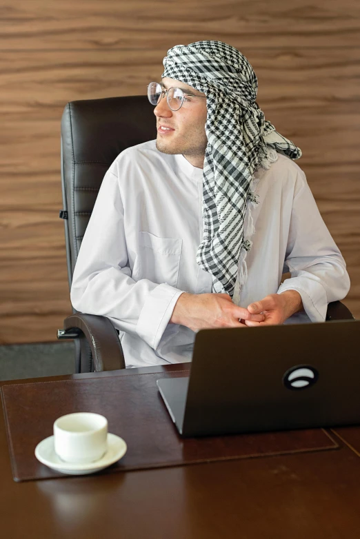 a man sitting at a desk in front of a laptop computer, inspired by Sheikh Hamdullah, pexels, wearing business casual dress, arab inspired, 2019 trending photo, the best