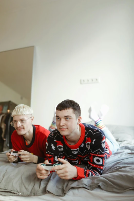 a group of young men sitting on top of a bed, reddit, realism, twins playing video games, non binary model, alex maksiov and john pugh, slide show