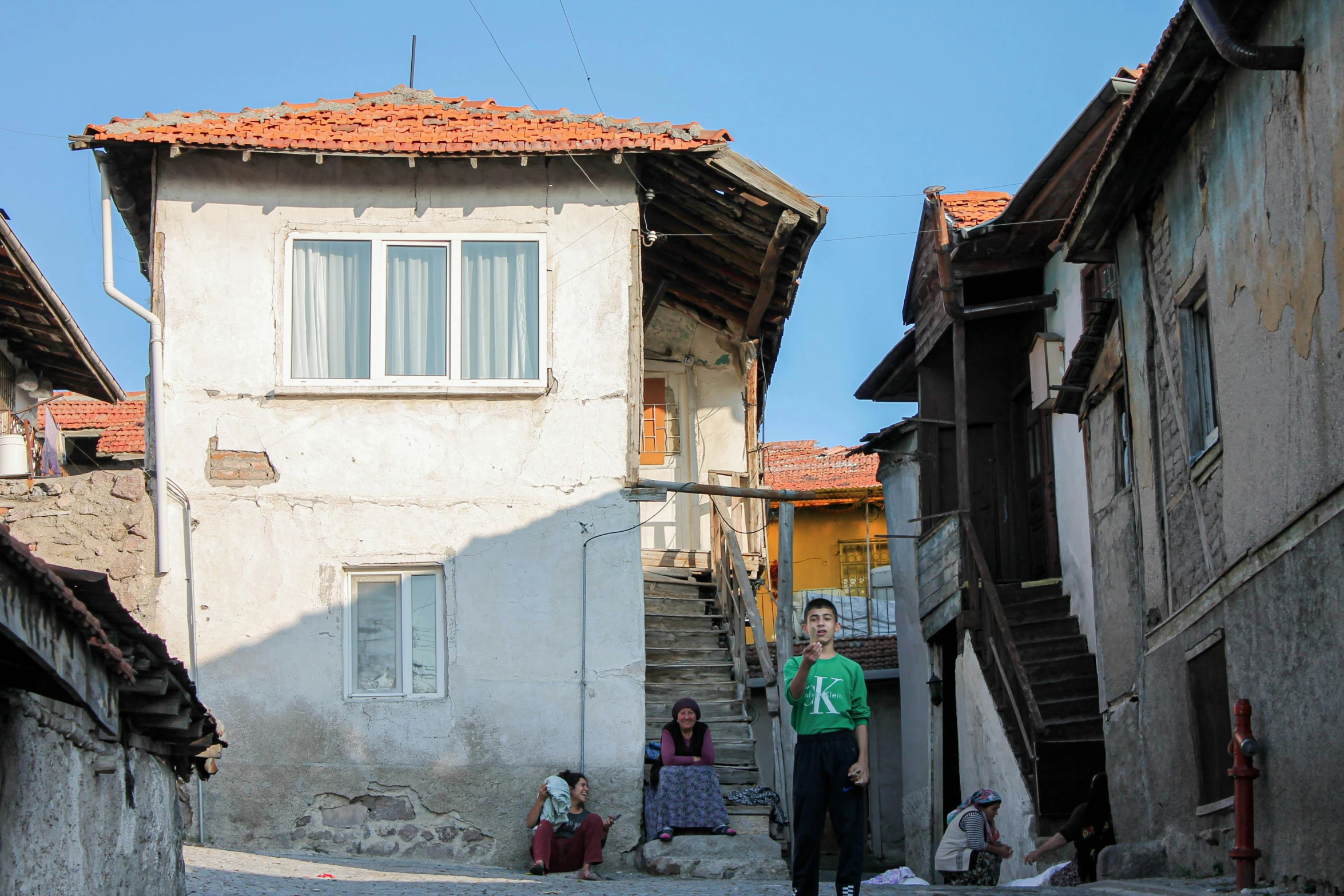 a man riding a skateboard down a cobblestone street, by Kogan Gengei, people looking at a house, built on a steep hill, portrait image, square